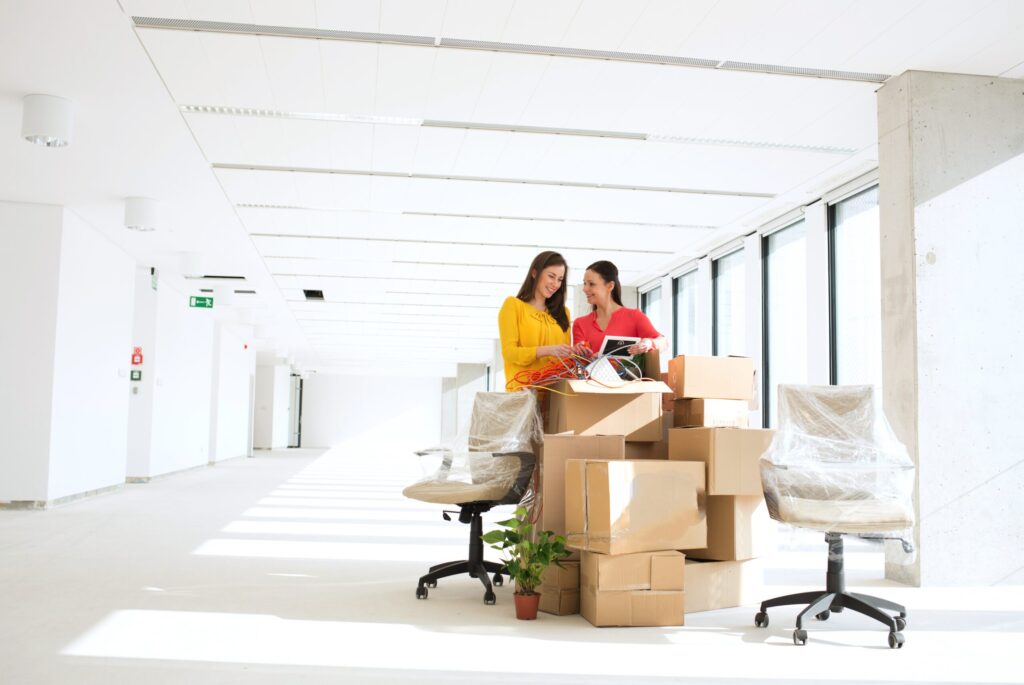 Businesswomen unpacking cardboard boxes